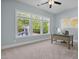 Bright home office featuring three windows, backyard views and a modern desk setup at 212 Blue Granite Dr, Holly Springs, NC 27540
