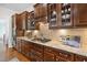 Gourmet kitchen features granite countertops, stainless steel appliances, and custom cabinetry with glass displays at 212 Blue Granite Dr, Holly Springs, NC 27540