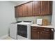 Functional laundry room with modern appliances and ample storage cabinets and light counter tops at 212 Blue Granite Dr, Holly Springs, NC 27540