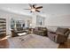 Bright living room with hardwood floors, ceiling fan, comfortable seating, and a large area rug at 212 Blue Granite Dr, Holly Springs, NC 27540