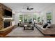 Bright living room with fireplace, sofas, and large windows overlooking the backyard at 212 Blue Granite Dr, Holly Springs, NC 27540