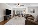 Bright living room with hardwood floors, ceiling fan, comfortable seating, and a large window at 212 Blue Granite Dr, Holly Springs, NC 27540