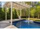Backyard pool area features a pergola with string lights, and a seating area at 212 Blue Granite Dr, Holly Springs, NC 27540