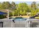 Backyard featuring a pool, slide, diving board, seating area, and mature landscaping at 212 Blue Granite Dr, Holly Springs, NC 27540