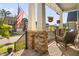 A cozy covered porch provides seating area with stone columns and hanging floral baskets at 212 Blue Granite Dr, Holly Springs, NC 27540