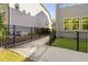 A fenced-in side yard shows a stone path and small garden area in between homes at 212 Blue Granite Dr, Holly Springs, NC 27540
