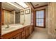 Bathroom with double sink vanity, wood cabinets, and a window with blinds at 213 Huntington Dr, Chapel Hill, NC 27514