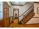 Warm entryway with hardwood floors, paneled walls and wood railing leading to upper floor at 213 Huntington Dr, Chapel Hill, NC 27514