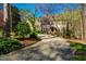 Charming two-story home with a gravel driveway, lush landscaping, and colorful trees in a peaceful setting at 213 Huntington Dr, Chapel Hill, NC 27514