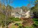 Exterior view showcasing a sunroom and a patio surrounded by lush trees and landscaping at 213 Huntington Dr, Chapel Hill, NC 27514