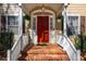 Close-up of the inviting red front door with white trim and decorative hanging flower baskets at 213 Huntington Dr, Chapel Hill, NC 27514