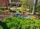Landscaped front yard with stone lined creek and lush green plants and bushes at 213 Huntington Dr, Chapel Hill, NC 27514