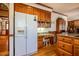 View of a kitchen featuring a built in desk area, white refrigerator, and hardwood floors at 213 Huntington Dr, Chapel Hill, NC 27514