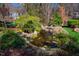 Picturesque backyard water feature surrounded by lush greenery, mature trees, and natural rock formations at 213 Huntington Dr, Chapel Hill, NC 27514
