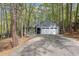 View of home's exterior with a two-car garage and long drive, nestled among beautiful mature trees at 227 Windlestraw, Pittsboro, NC 27312
