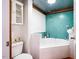 Bright bathroom featuring white and turquoise tiles with a built-in bathtub at 2281 Lamont Norwood, Pittsboro, NC 27312