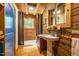 Rustic bathroom featuring wood paneling, pedestal sink, and window for natural light at 2281 Lamont Norwood, Pittsboro, NC 27312