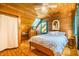 Bedroom boasts wood-paneled walls, skylight, ceiling fan, and a comfortable bed, exuding rustic charm at 2281 Lamont Norwood, Pittsboro, NC 27312