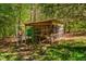 Outdoor chicken coop surrounded by lush greenery and trees at 2281 Lamont Norwood, Pittsboro, NC 27312