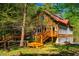 Inviting two-story home with wooden decks and steps, surrounded by mature trees and a green lawn at 2281 Lamont Norwood, Pittsboro, NC 27312
