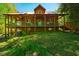 A log cabin-style home showing an elevated porch with rocking chairs. The home has an attached covered porch at 2281 Lamont Norwood, Pittsboro, NC 27312