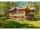 Charming wooden home with large windows and a red metal roof nestled among lush greenery at 2281 Lamont Norwood, Pittsboro, NC 27312