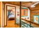 Hallway with wood paneling and railing leading to a bedroom with a glimpse of the bed and ceiling fan at 2281 Lamont Norwood, Pittsboro, NC 27312