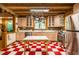 Charming kitchen featuring red and white checkered floors, stainless steel appliances, and ample cabinet space at 2281 Lamont Norwood, Pittsboro, NC 27312