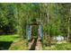 A decorative archway entrance leads to the backyard woods. An off-white propane tank is nestled in the woods at 2281 Lamont Norwood, Pittsboro, NC 27312