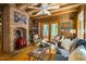 Log cabin living room with exposed beams, brick fireplace, and cozy seating area at 2281 Lamont Norwood, Pittsboro, NC 27312