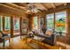 Cozy log cabin living room with hardwood floors, exposed beams, and ample natural light at 2281 Lamont Norwood, Pittsboro, NC 27312