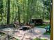 Outdoor patio with seating area and fire pit, surrounded by trees at 2281 Lamont Norwood, Pittsboro, NC 27312
