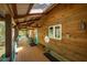 Covered porch featuring wood paneling, rocking chairs, and a view of the surrounding nature, inviting relaxation at 2281 Lamont Norwood, Pittsboro, NC 27312