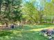 Expansive green backyard with a rustic wooden play area and a gazebo in a peaceful, wooded setting at 2281 Lamont Norwood, Pittsboro, NC 27312