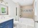 Updated bathroom featuring a blue vanity, neutral tile, and a modern shower-tub combination at 2419 George Anderson Dr, Hillsborough, NC 27278