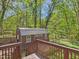 Exterior view of the backyard shed with wood siding and metal roof, accessible from the deck at 2419 George Anderson Dr, Hillsborough, NC 27278