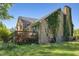 Exterior view of the back of the house featuring a chimney with vines and a wooden deck at 2510 Poplar Creek Rd, Henderson, NC 27537