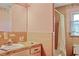 Interior shot of a dated peach-colored bathroom featuring a bathtub and sink at 2510 Poplar Creek Rd, Henderson, NC 27537