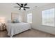 This bright bedroom includes neutral walls and carpet, a ceiling fan, and many windows at 275 Sunrise Ridge Dr, Willow Springs, NC 27592