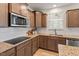Well-lit kitchen featuring granite countertops, stainless appliances, and wooden cabinets at 275 Sunrise Ridge Dr, Willow Springs, NC 27592