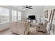 Bright living room featuring neutral tones, comfortable seating, and natural light from large windows at 275 Sunrise Ridge Dr, Willow Springs, NC 27592