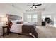 Spacious bedroom suite featuring a tufted headboard, ceiling fan, and adjacent office space at 275 Sunrise Ridge Dr, Willow Springs, NC 27592
