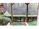 A backyard view showcasing a well-maintained hedgerow, viewed through a wooden pergola at 2750 Laurelcherry St, Raleigh, NC 27612