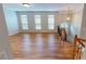 Open-concept living room with hardwood floors, large windows, and a staircase at 2750 Laurelcherry St, Raleigh, NC 27612