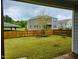 Covered patio view of a fenced backyard with a tree, a swing set and green grass at 2901 Murray Ridge Trl, Apex, NC 27502
