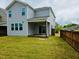 View of the back of the house with a covered patio and a well-maintained lawn with a wooden fence at 2901 Murray Ridge Trl, Apex, NC 27502