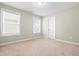 Comfortable bedroom featuring carpet flooring, two windows and a closet at 2901 Murray Ridge Trl, Apex, NC 27502