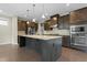 Modern kitchen with a large island, stainless steel appliances, and dark wood cabinets at 2901 Murray Ridge Trl, Apex, NC 27502