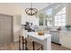 Stylish kitchen featuring white cabinets, stainless steel appliances, a kitchen island, and a large window at 314 Bledsoe Ave, Raleigh, NC 27601