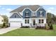 Charming two-story home featuring a mix of blue and white siding and a well-manicured lawn at 315 Adams Pointe Ct, Angier, NC 27501